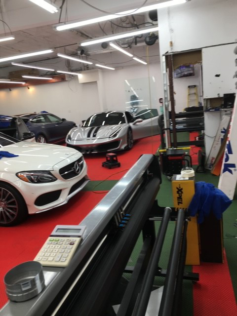 Vehicles in an automotive work bay being prepped for window tint